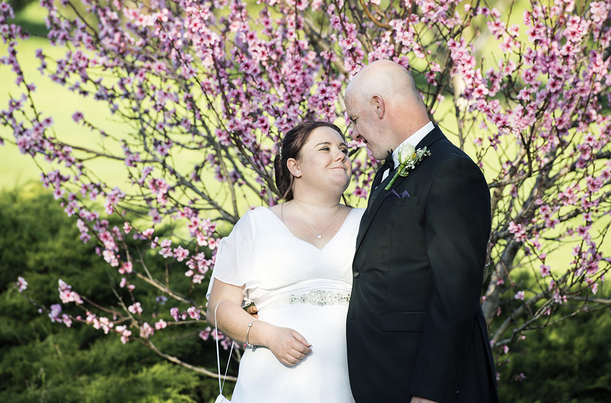 rendezvous experience wedding - eleanor & justin 29 Smiling in front of pink flowers
