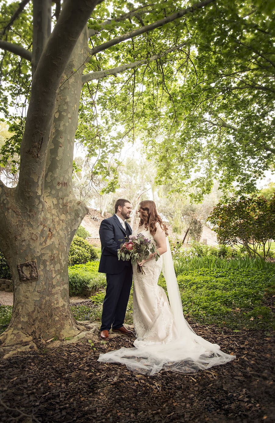 4 crucial details your wedding photographer must know 32 Bride and groom under the leaves at the Stockade Botanic Park