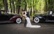 Passionate kiss in between wedding cars