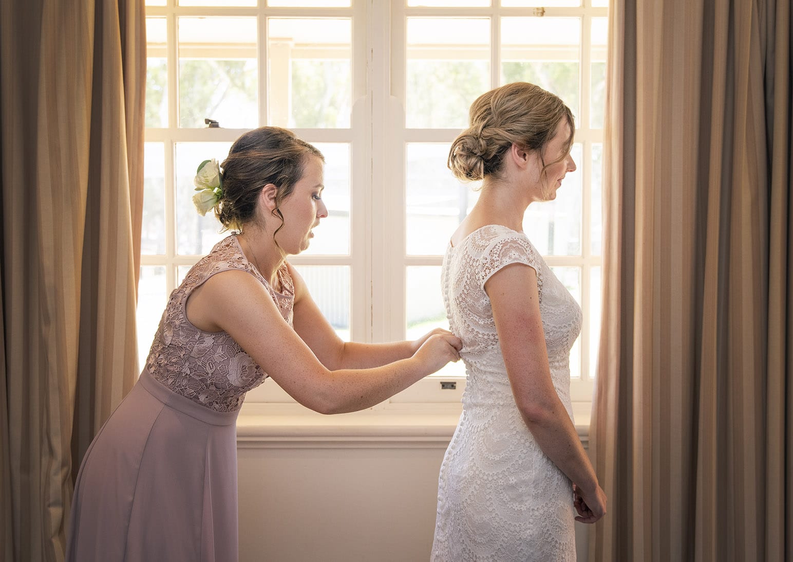 serafino wines wedding - claire & arron 30 Bridesmaid helping with lacing up wedding dress