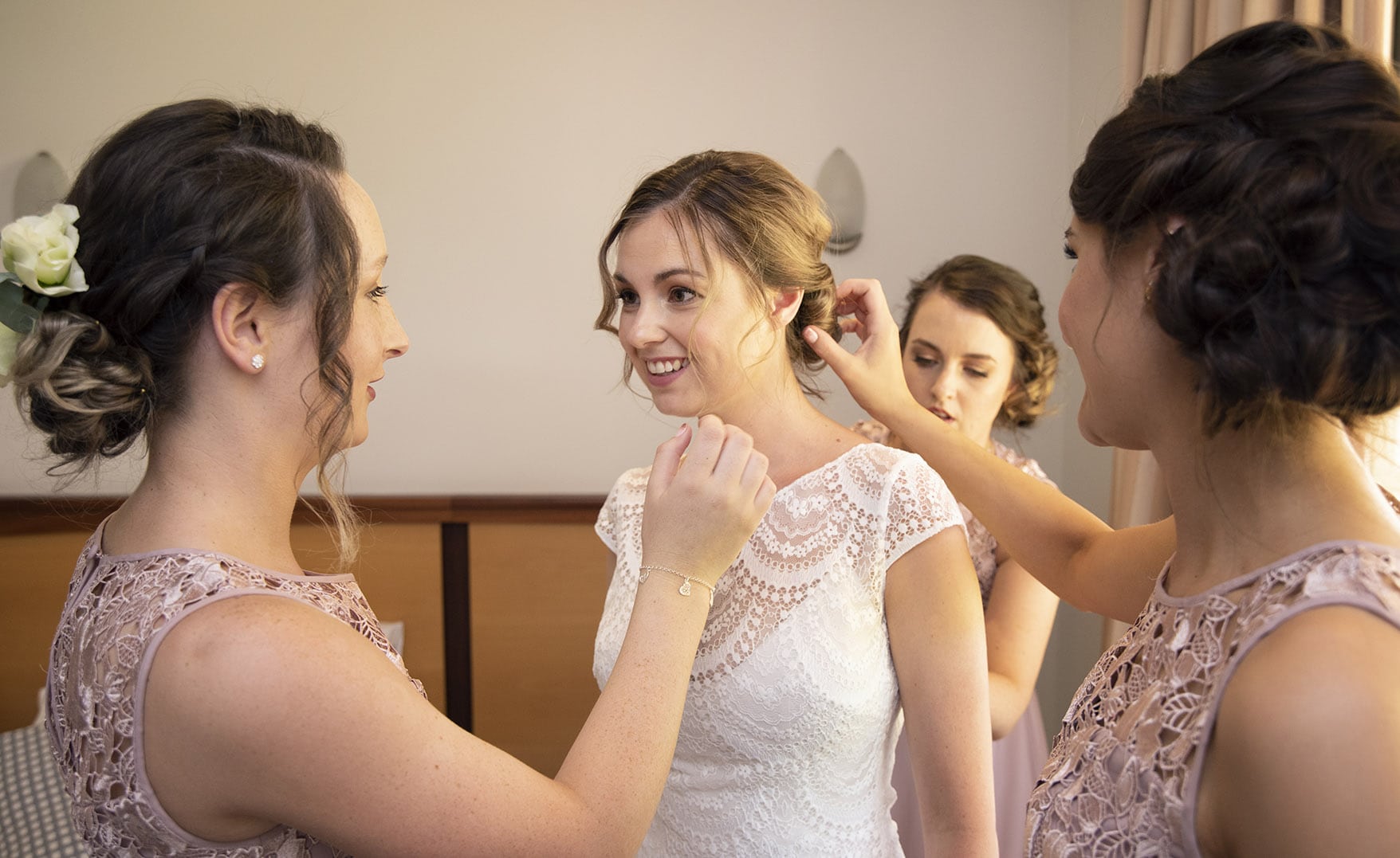 serafino wines wedding - claire & arron 27 Bridesmaids helping put on wedding dress
