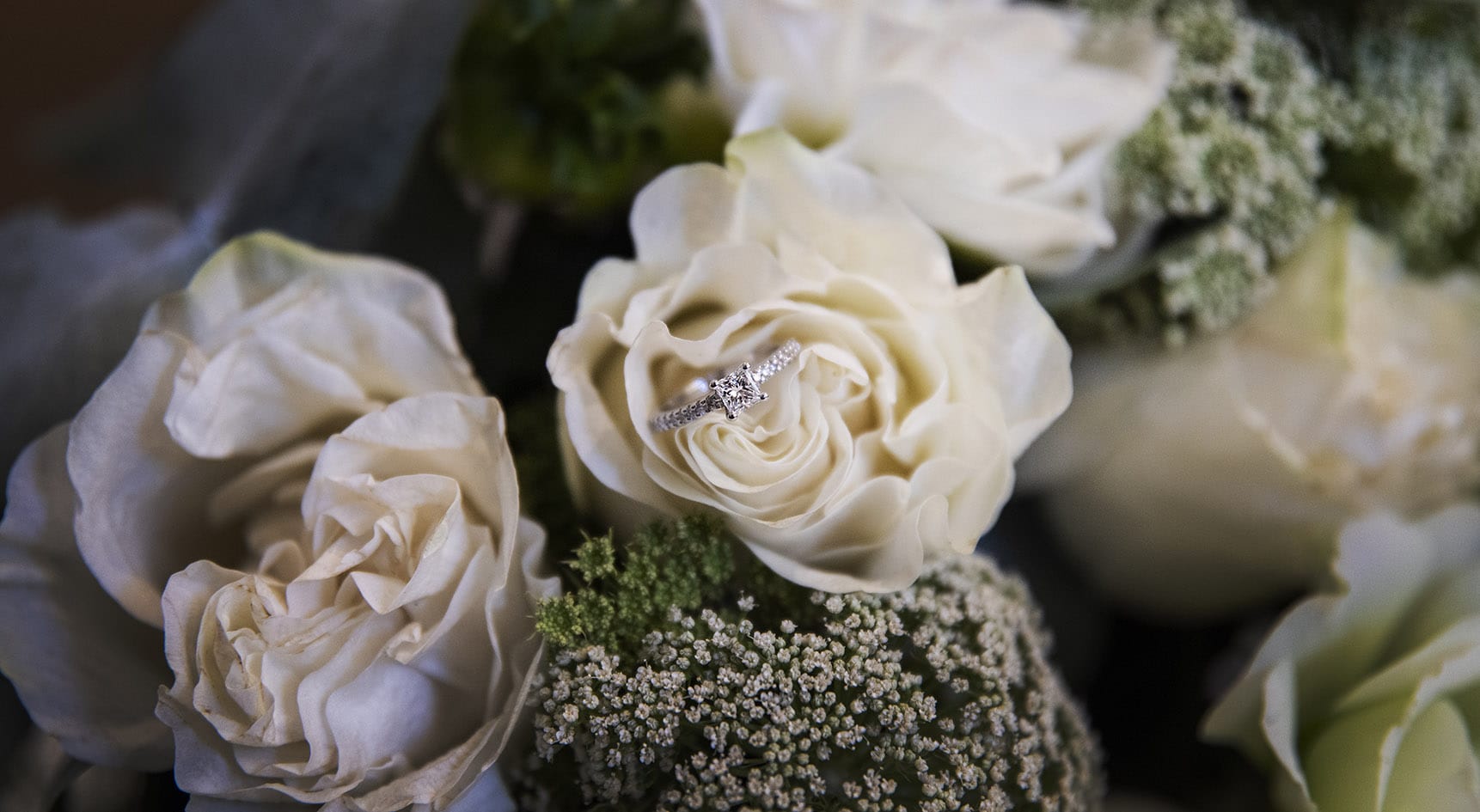 serafino wines wedding - claire & arron 19 engagement ring perched amongst the flowers