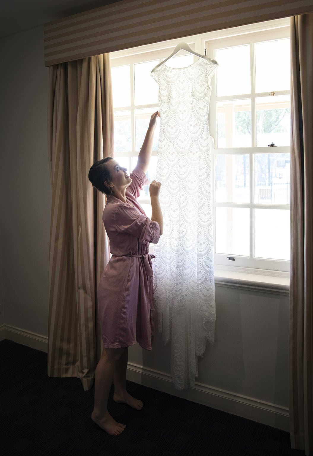 serafino wines wedding - claire & arron 24 Reaching for the wedding dress