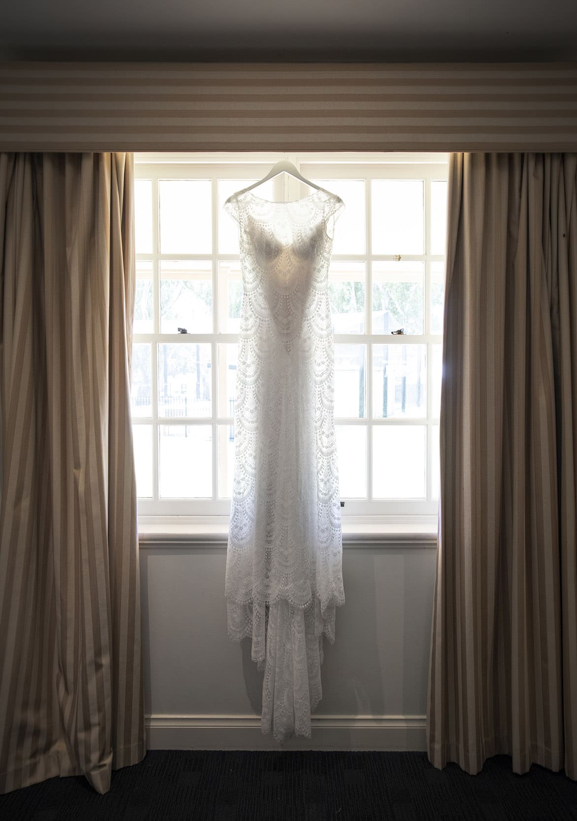 serafino wines wedding - claire & arron 20 Wedding dress hanging in werafino wines window