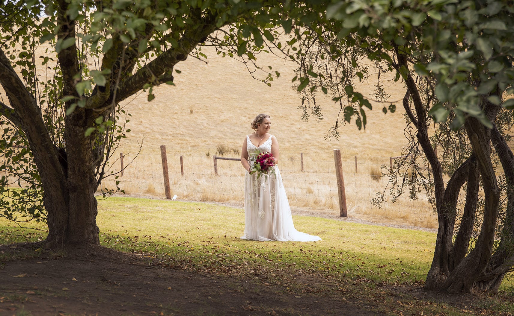 old oval estate wedding - suzie & jay 74 bride standing under arch of tree
