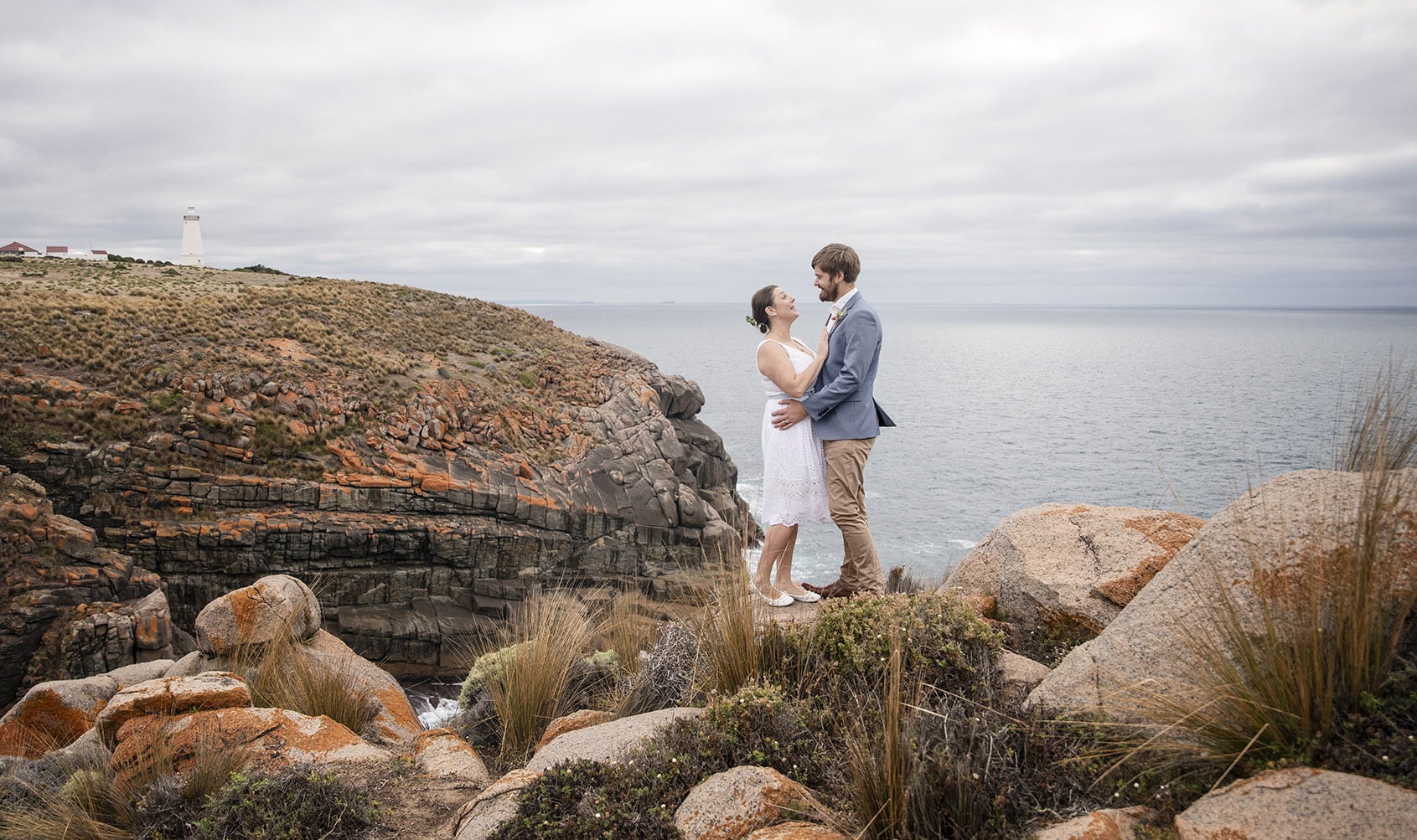 kangaroo island elopement - claire & jacob 21 Claire and Jacob embracing on a rocky coastal cliff near Cape Willoughby Lighthouse, Kangaroo Island