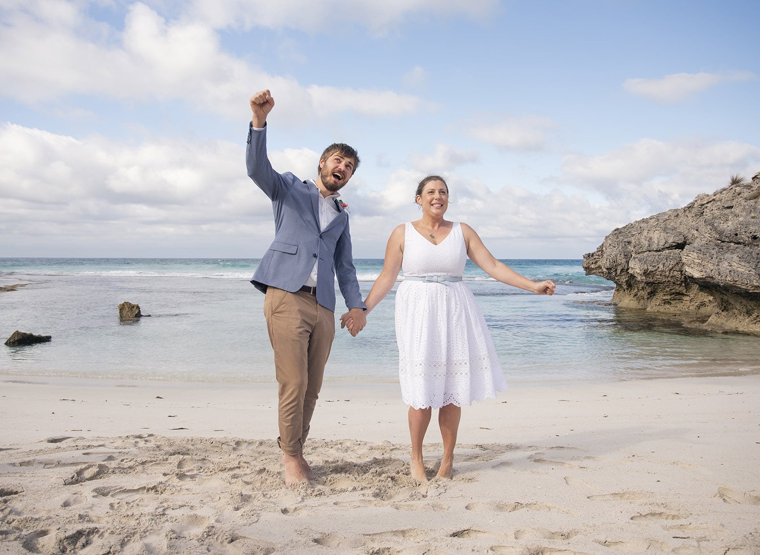 kangaroo island elopement - claire & jacob 33 Claire and Jacob celebrating barefoot on the sand at Pennington Bay, with ocean waves and rocky cliffs behind them