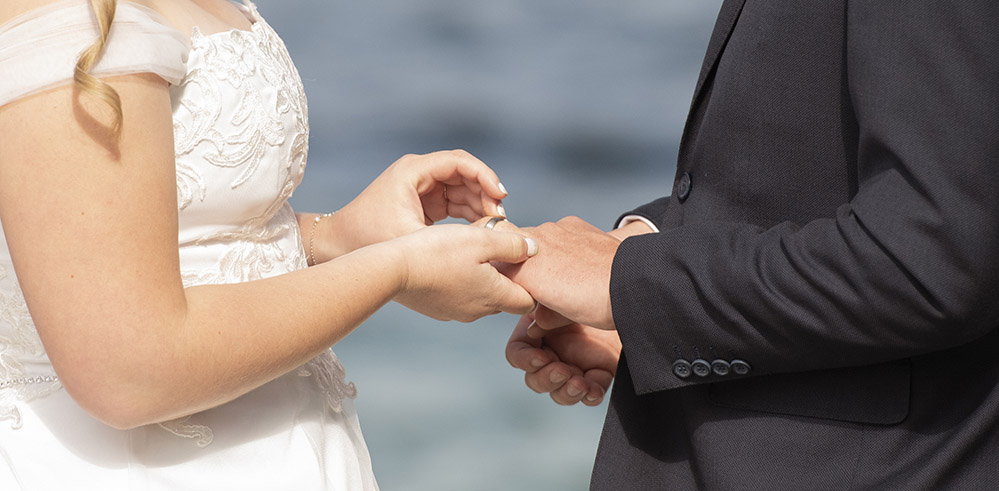 Exchanging wedding bands in front of Hobart Harbour