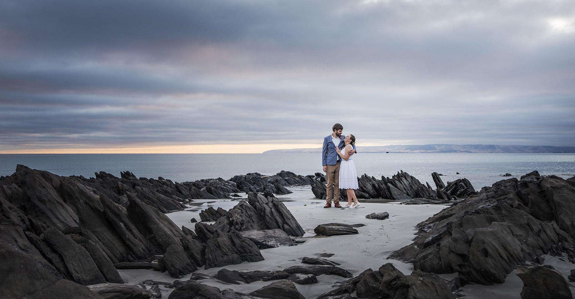 kangaroo island elopement - claire & jacob 3 Claire and Jacob embracing on the rocky shore at Frenchman's Rock, Kangaroo Island