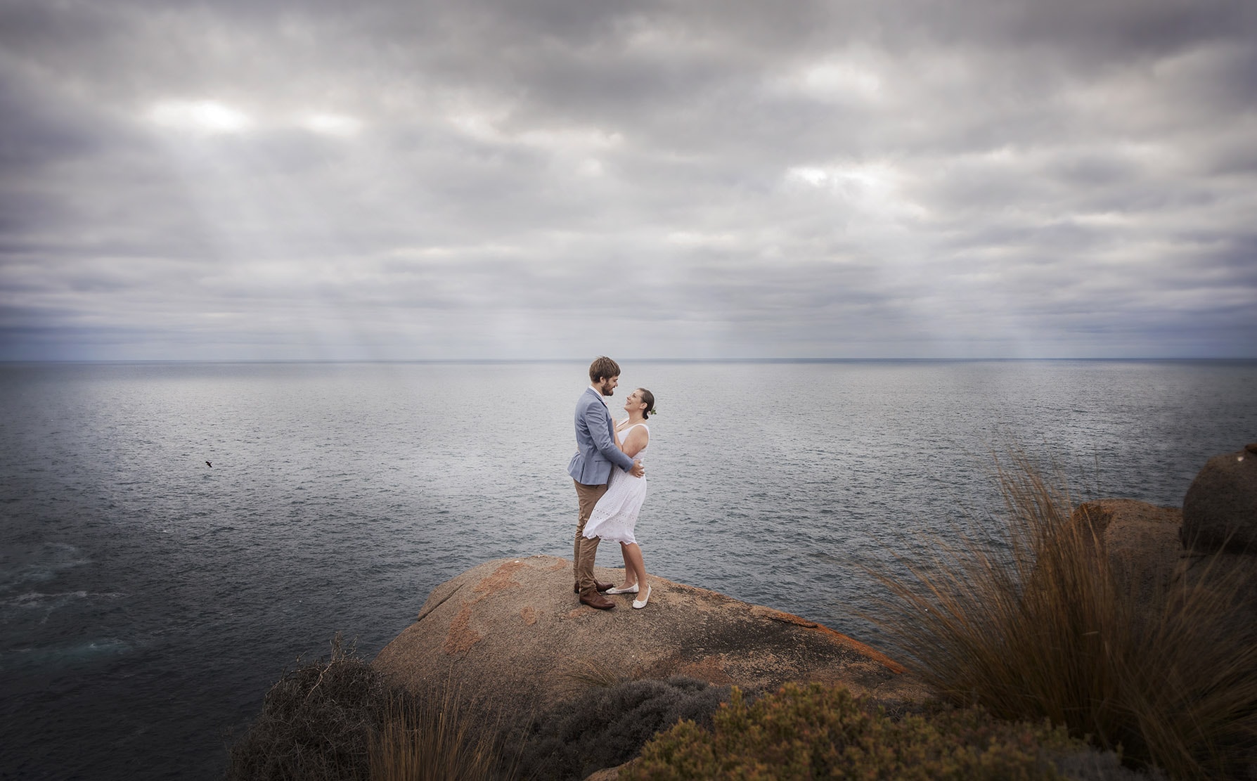 kangaroo island elopement - claire & jacob 20 Claire and Jacob embracing on a rocky clifftop above the ocean during their Kangaroo Island elopement