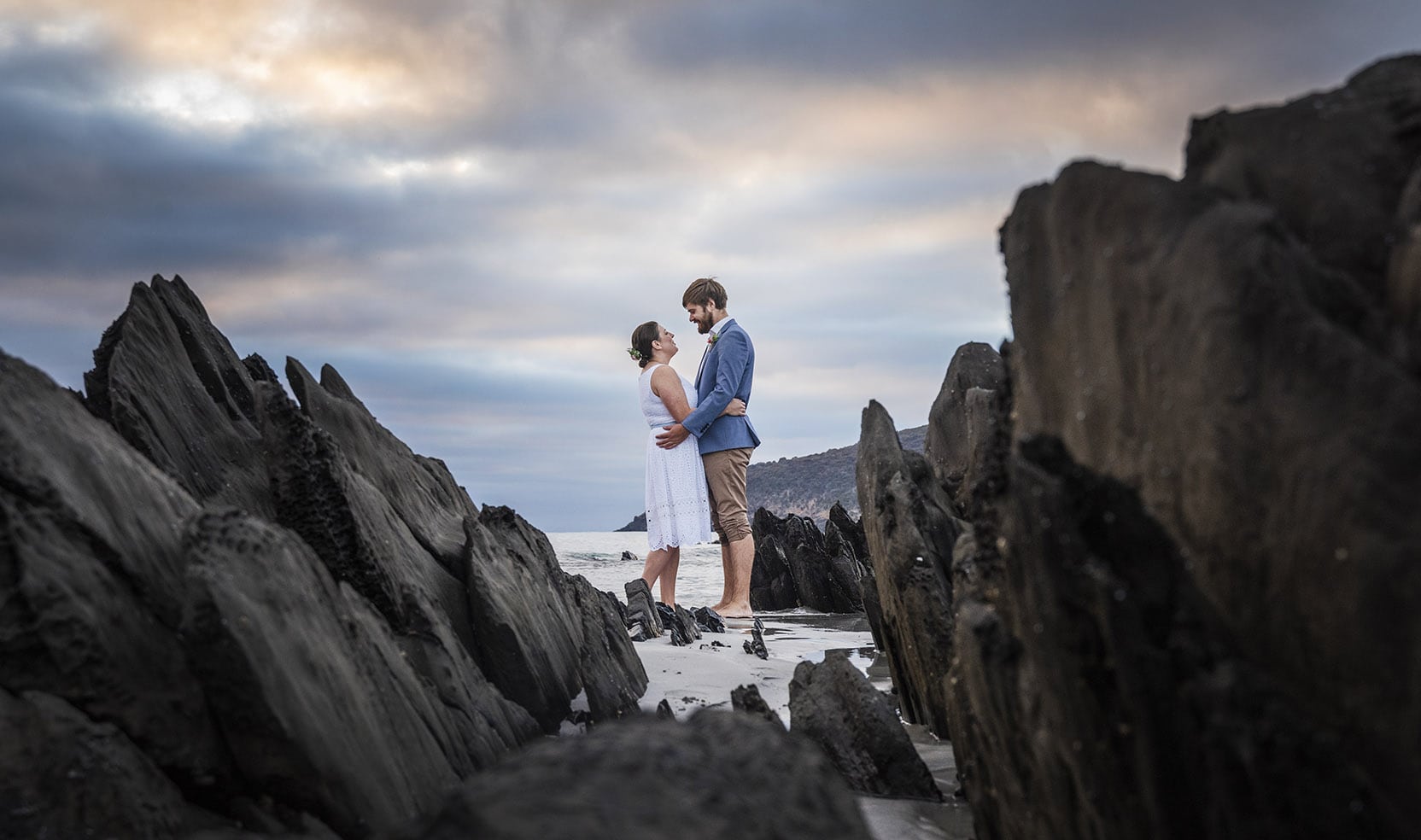 5 wedding moments that look good when naturally captured 11 Claire and Jacob embracing between dark rock formations on a Kangaroo Island beach