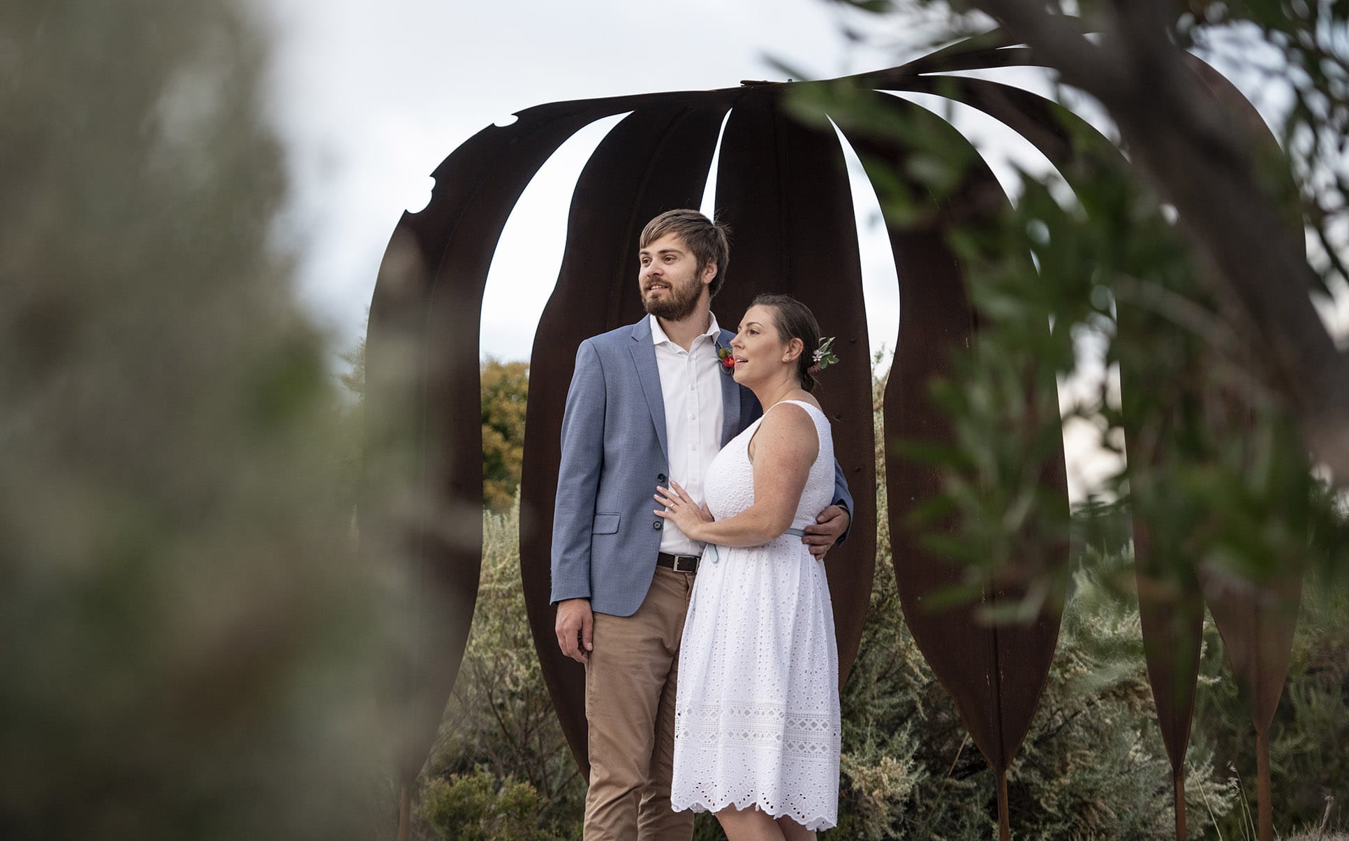 kangaroo island elopement - claire & jacob 10 Claire and Jacob standing beneath a large rusted metal sculpture during their Kangaroo Island elopement photoshoot