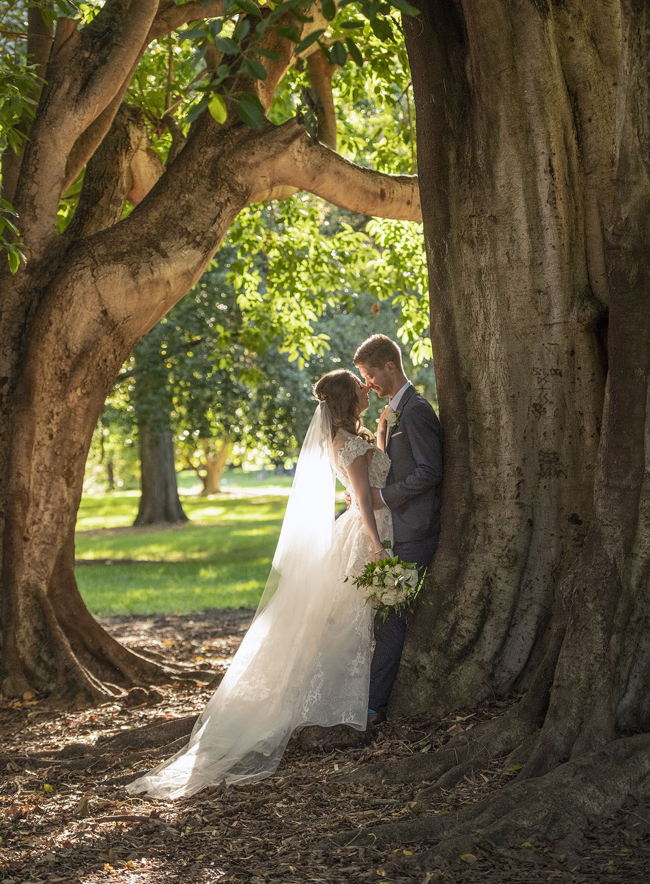 national wine center wedding - pat & kat 168 Bride and groom leaning against a fig tree