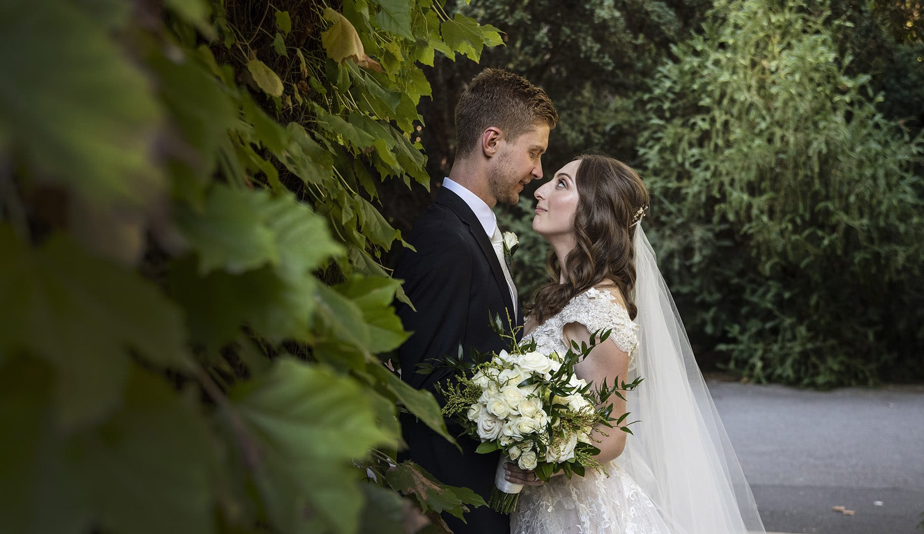 bride and groom leaning against the gate house bride and groom leaning against the gate house