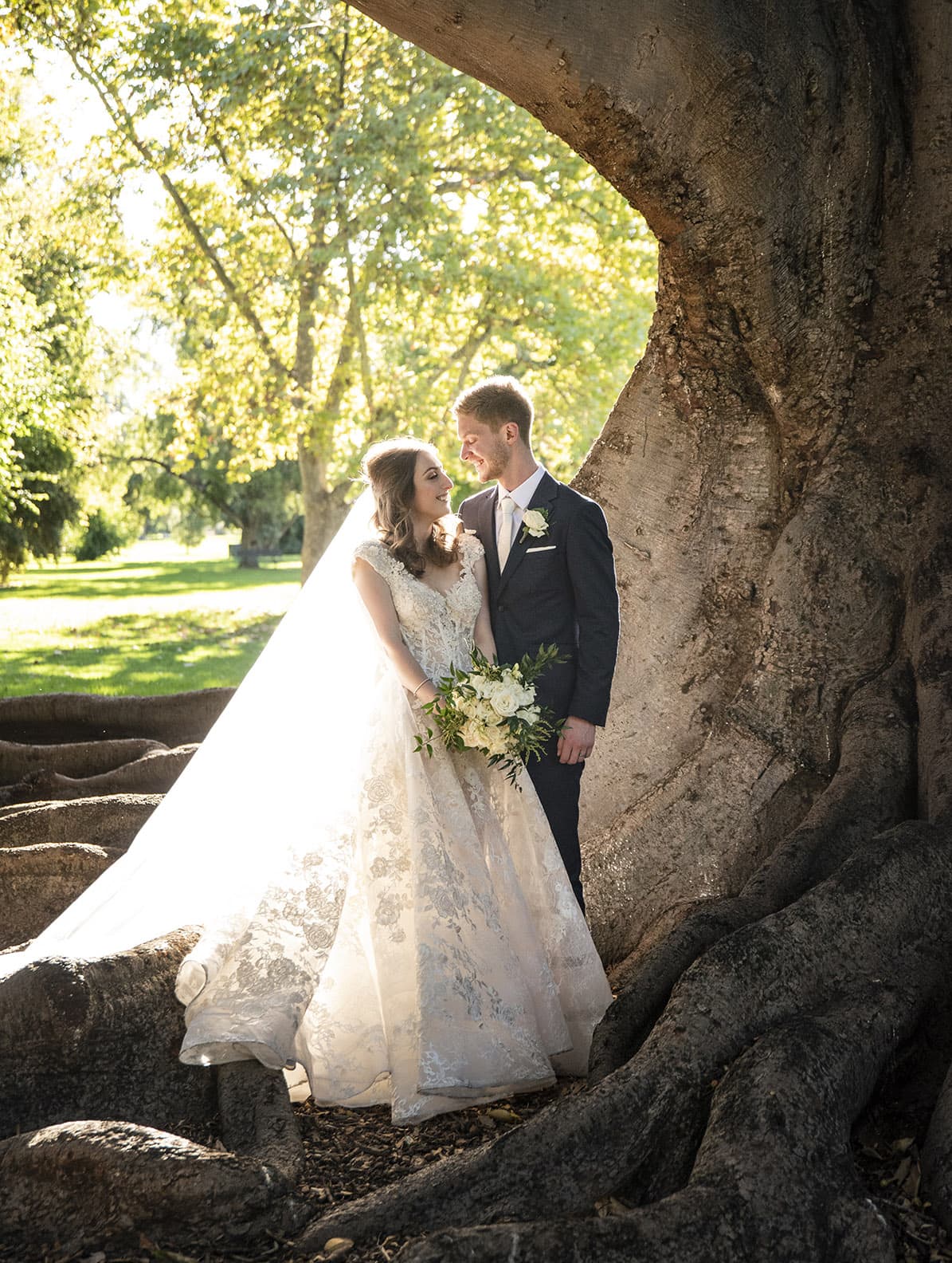 national wine center wedding - pat & kat 166 Standing together near a large fig tree