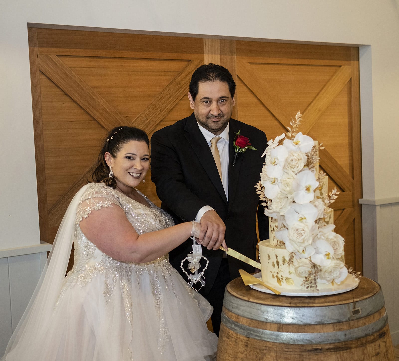lake breeze wines wedding - cate & renato 53 Bride and groom cutting wedding cake in front of doorway