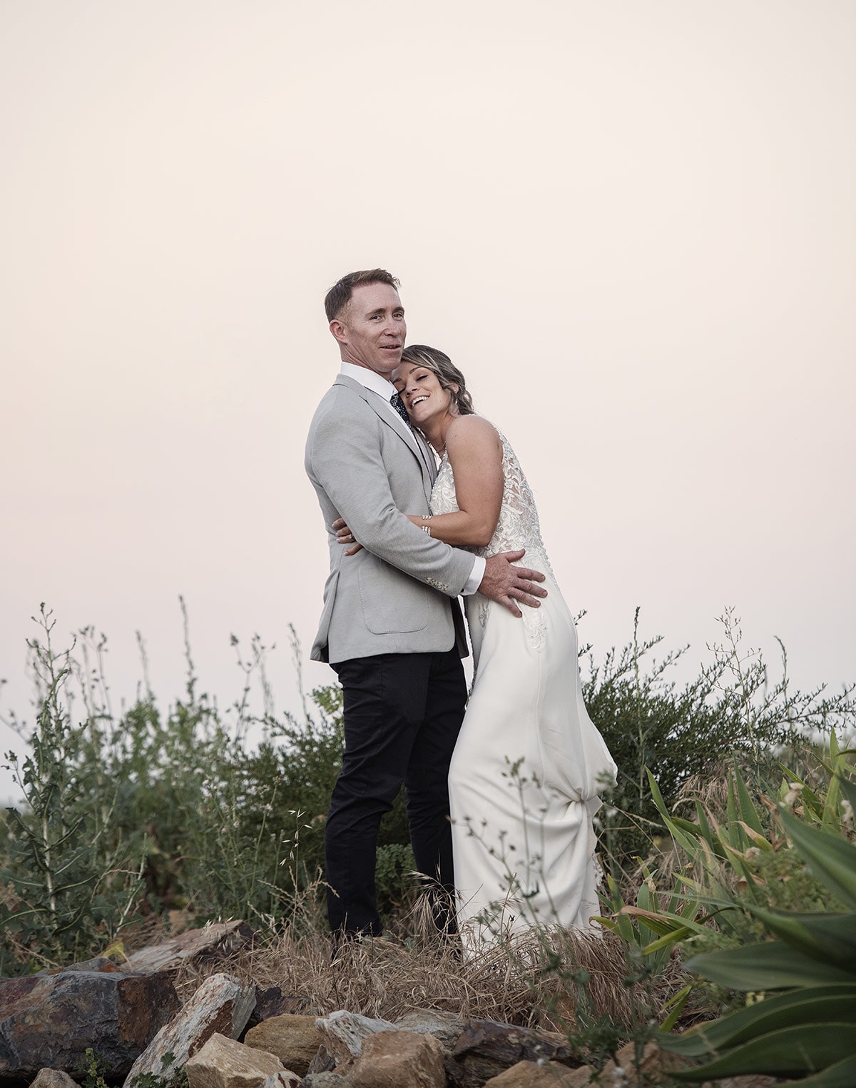 big easy radio wedding - leanne & evan 61 Bride and groom hugs under pink sky