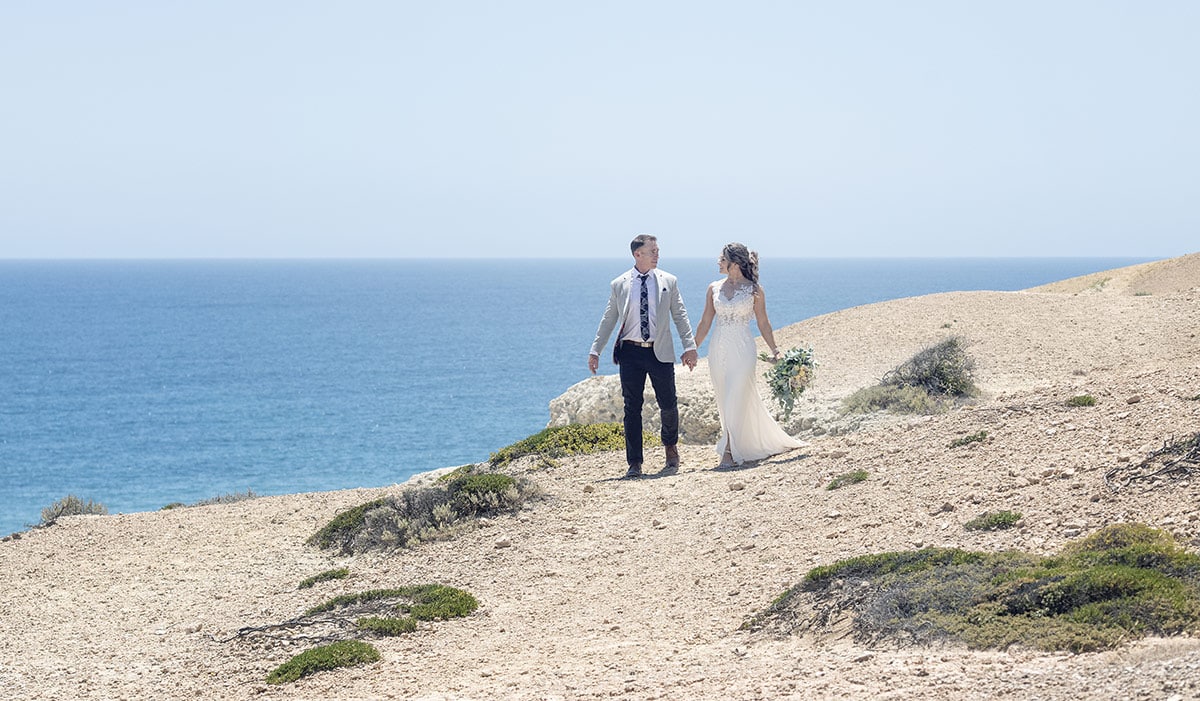 big easy radio wedding - leanne & evan 23 Bride and groom waling along the cliff face