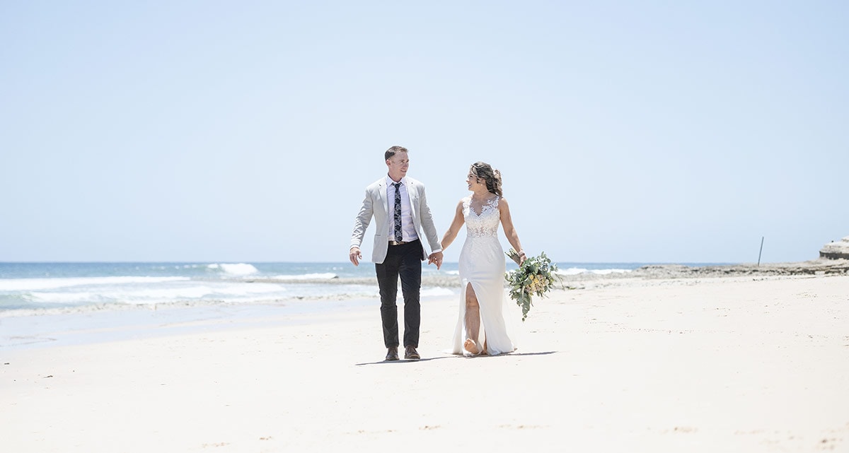 big easy radio wedding - leanne & evan 19 bride and groom walking along the sand