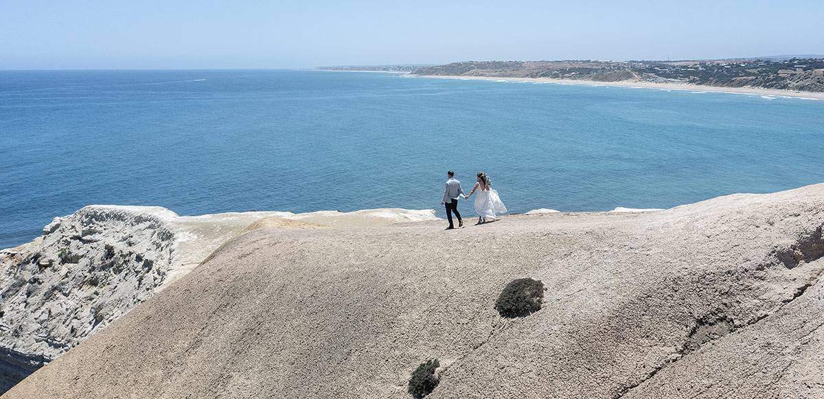 big easy radio wedding - leanne & evan 14 bride and groom walking on cliffs