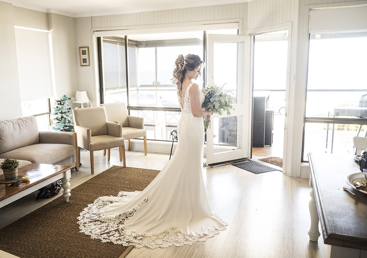 big easy radio wedding - leanne & evan 6 Bride standing alone in beach house