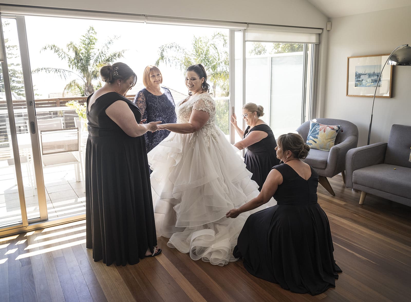 lake breeze wines wedding - cate & renato 15 bridesmaids helping with wedding gown