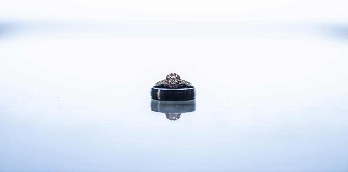 big easy radio wedding - leanne & evan 2 Wedding rings on glossy table