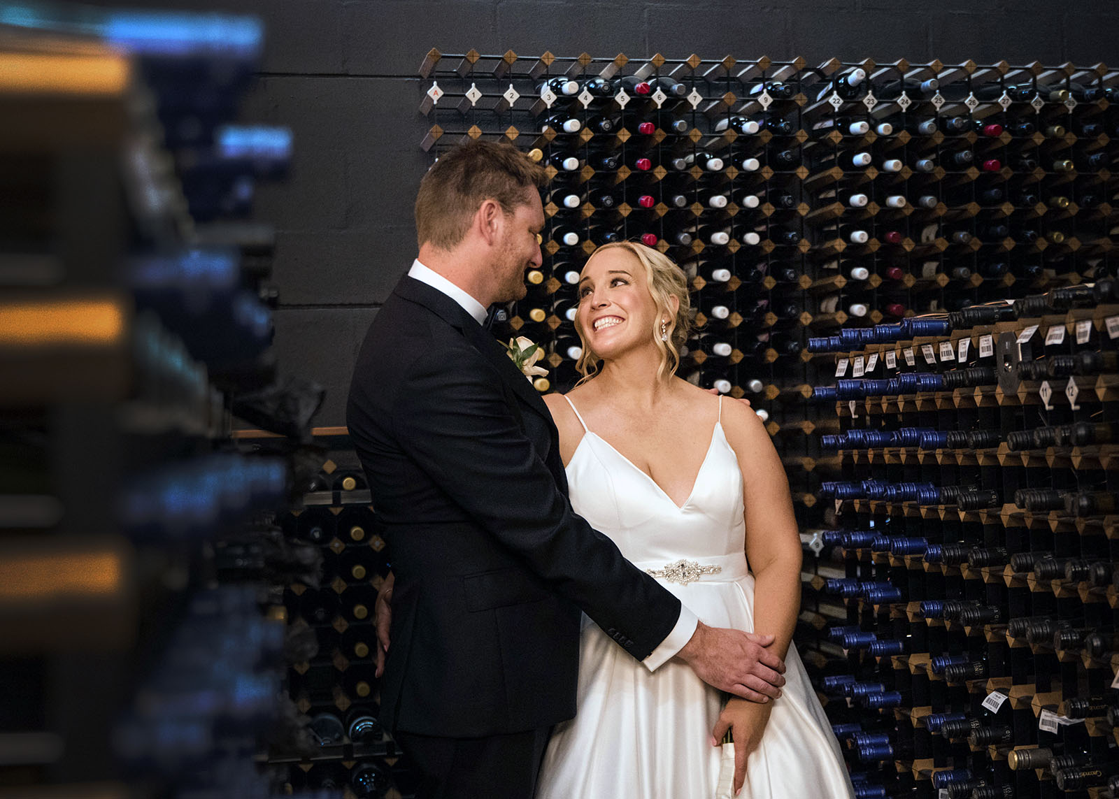 adelaide botanic gardens cycad collection wedding - joanne & blake 36 Bride and groom in the Adelaide Wine center cellar smiling