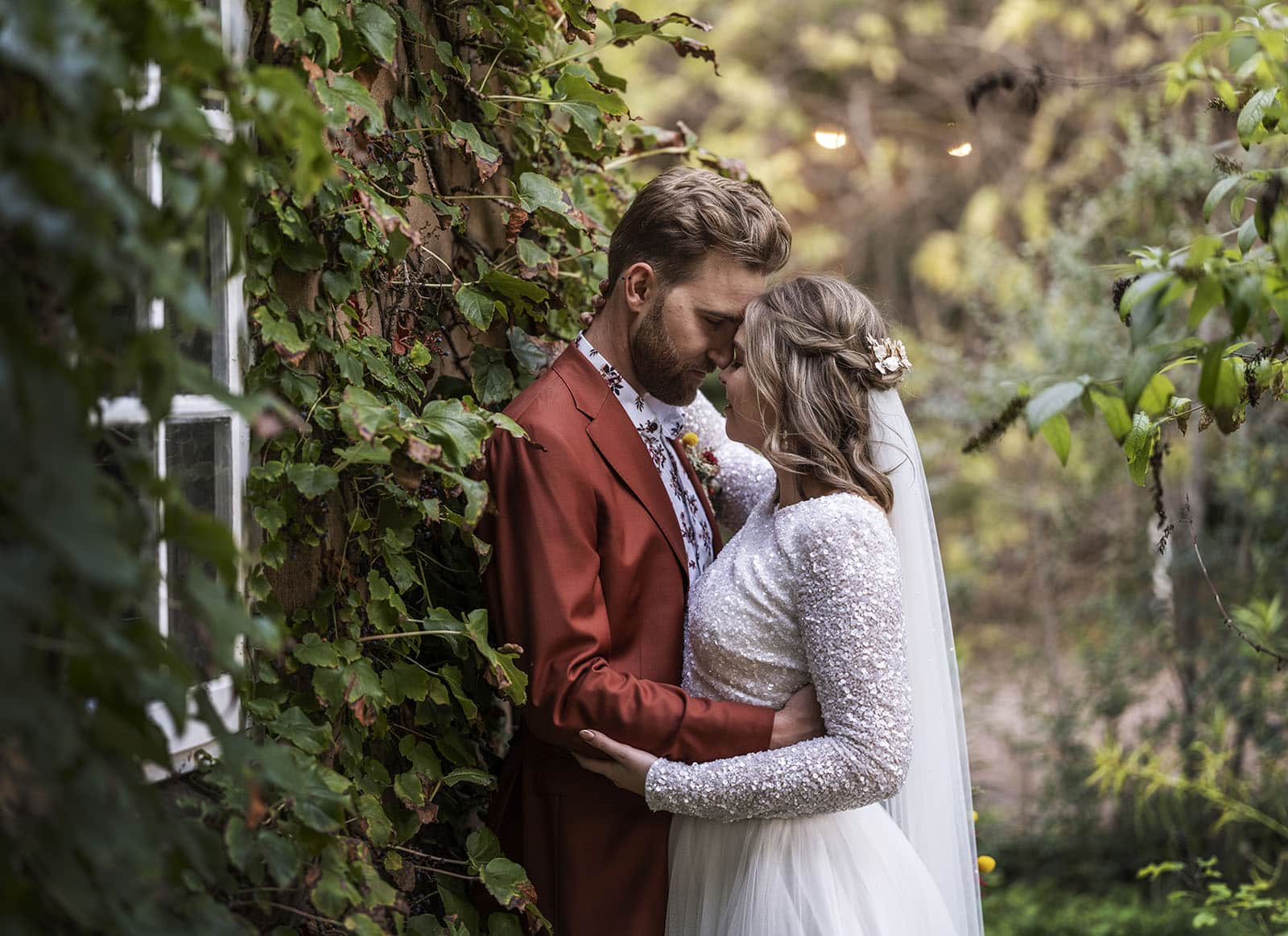Bride and groom headbutt in ivy