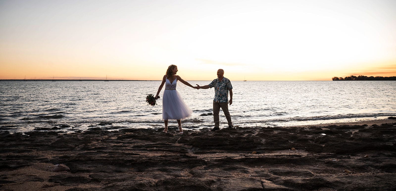 darwin's dudley point wedding - melanie & kerry 45 bride leads groom along beachfront