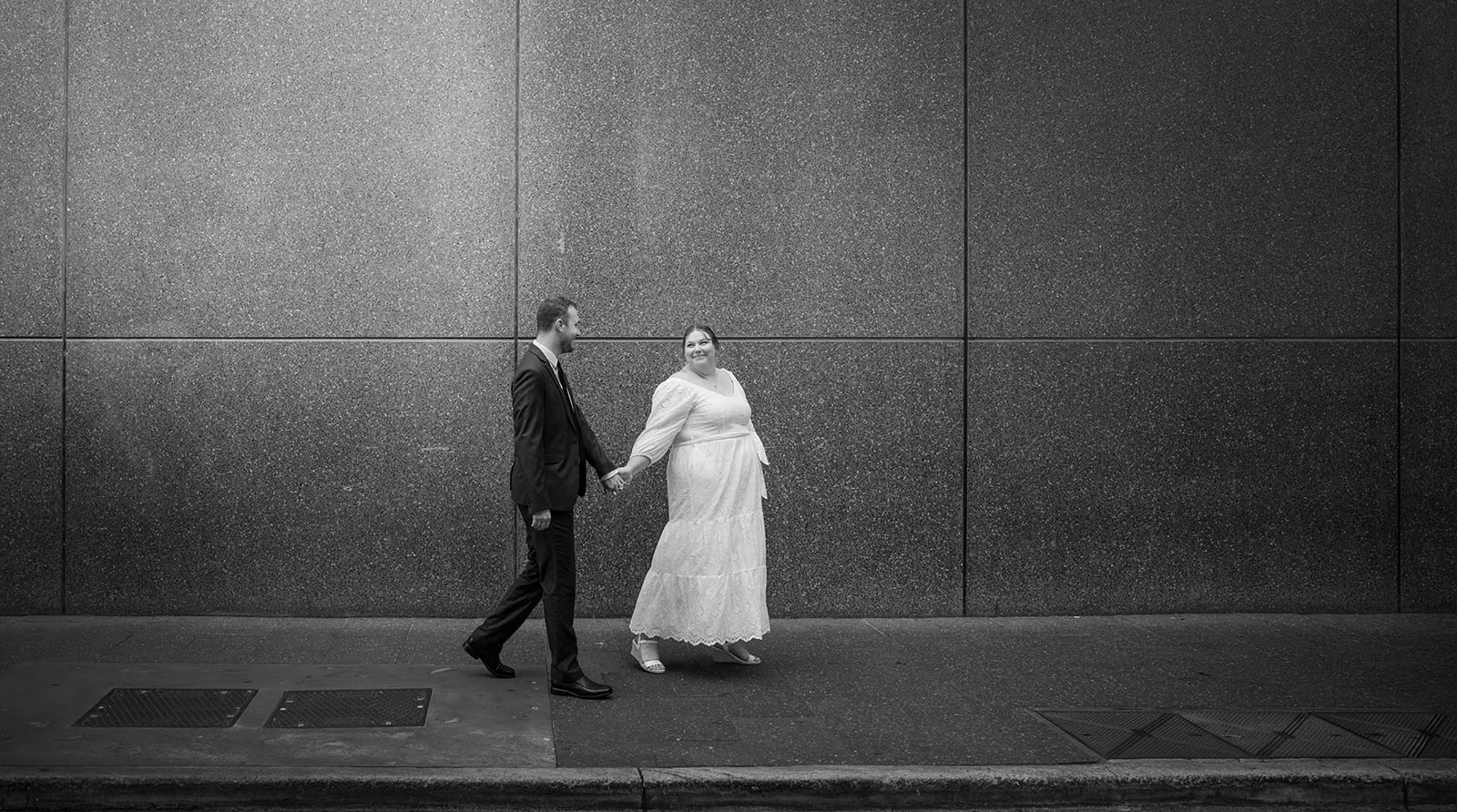 marriages registration office wedding - dayna & alex 13 Bridal couple walking along blank wall