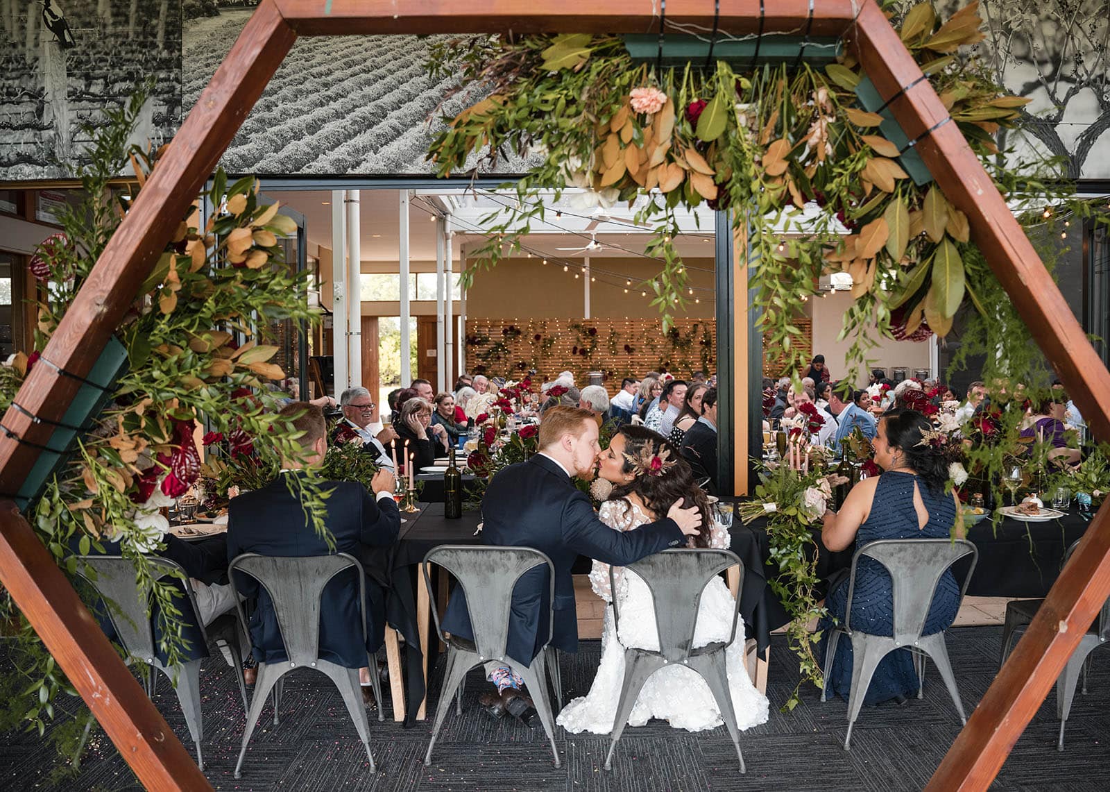 ekhidna winery wedding - chami & bryce 57 bridal kiss under arbour at reception