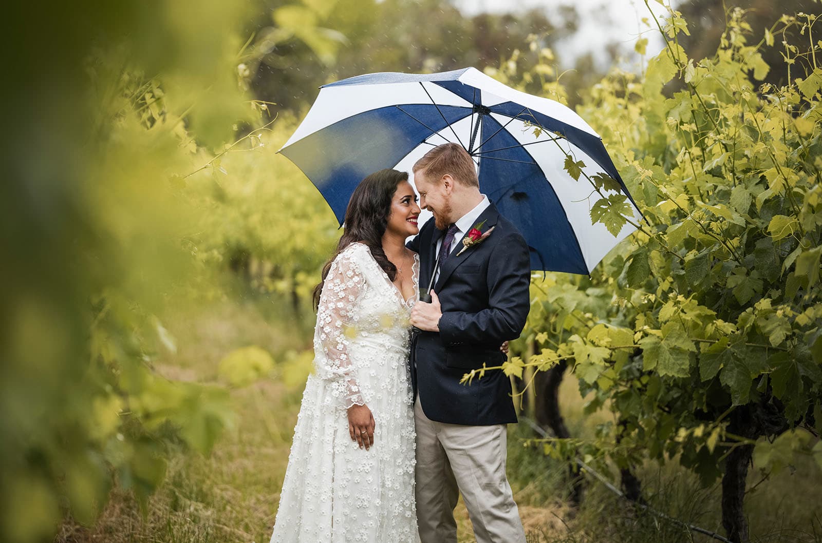 ekhidna winery wedding - chami & bryce 21 Bride and groom under umbrella in vineyard