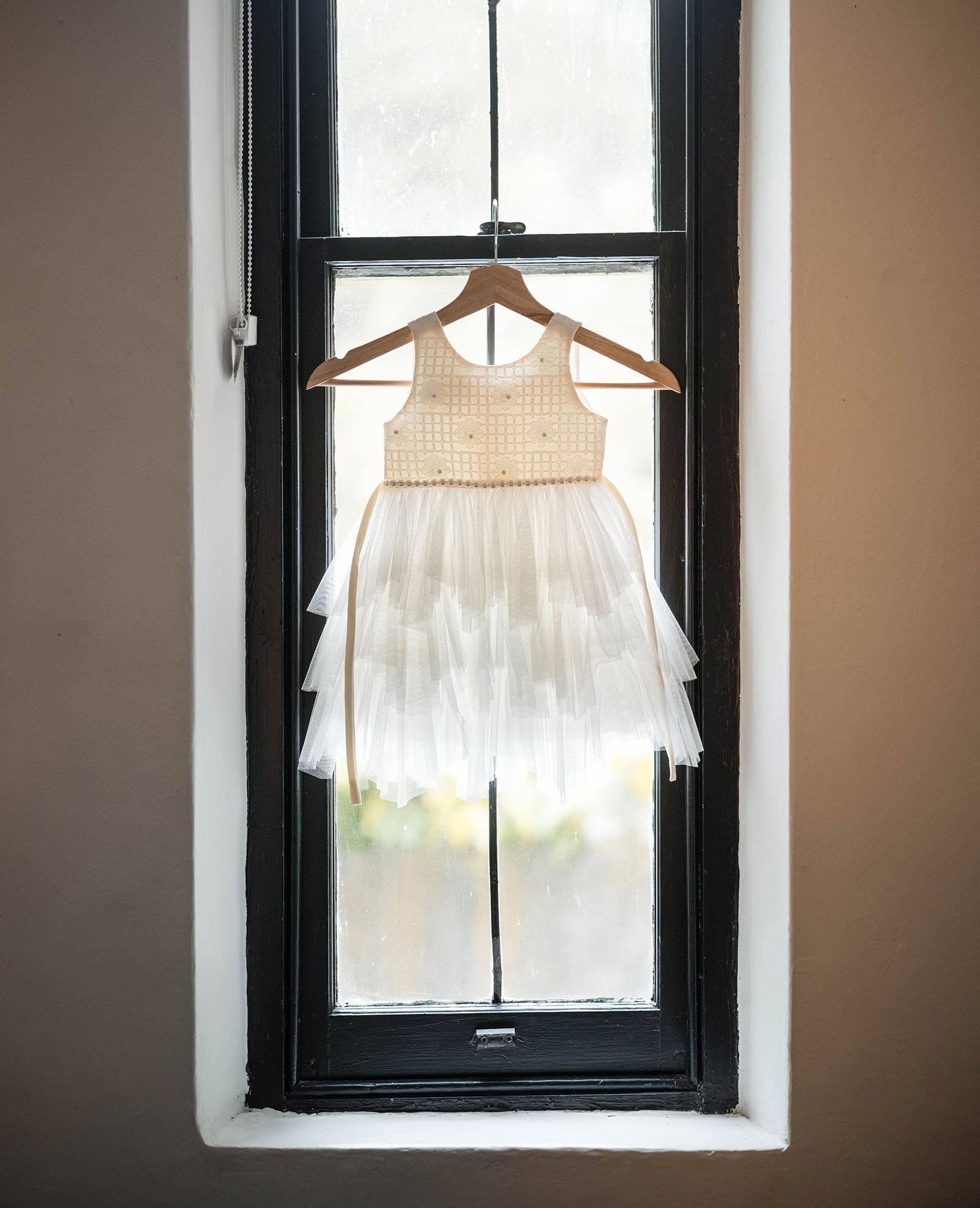 the manor basket range wedding - cassie & danny 16 Flower girl dress hanging in window