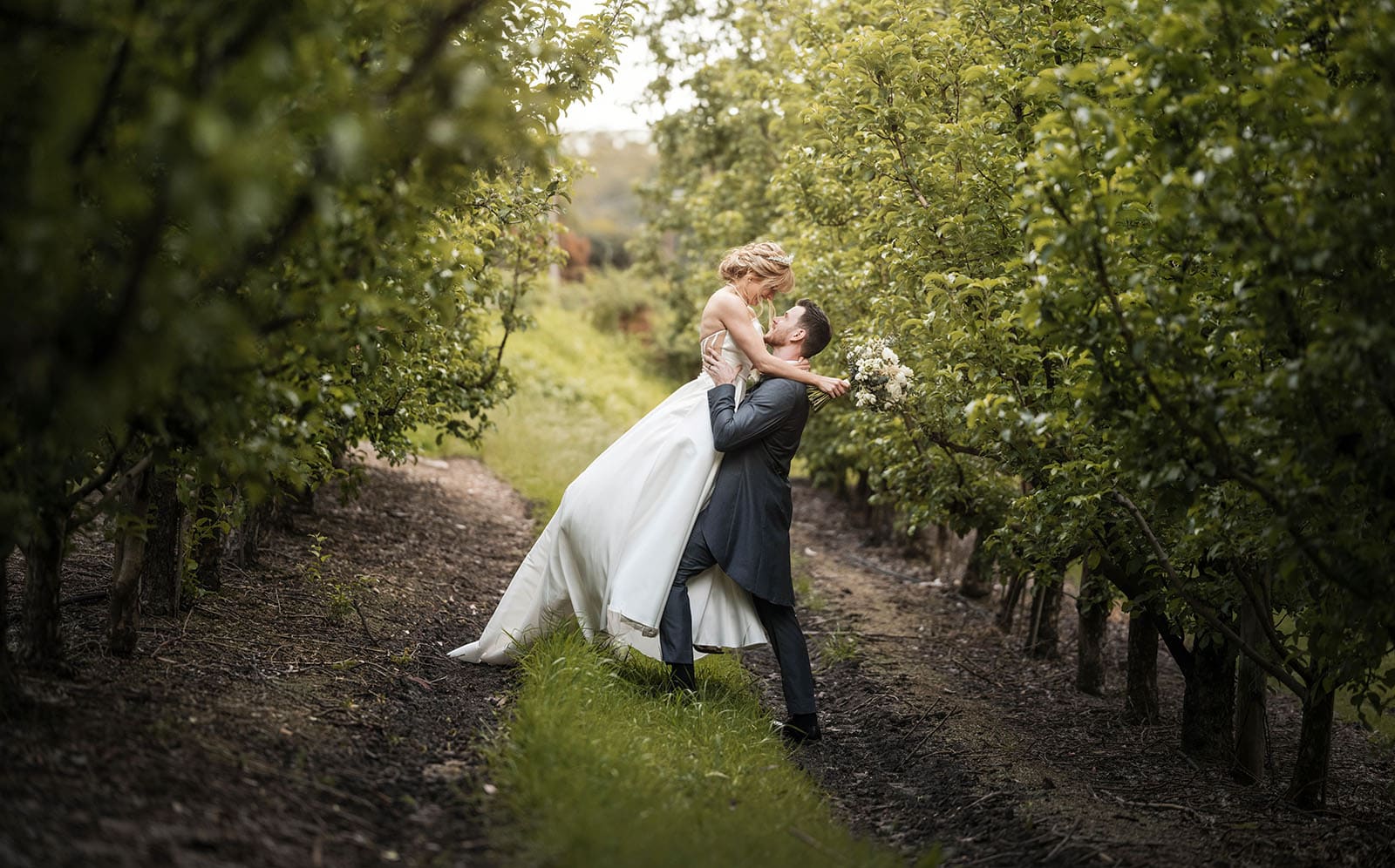 the manor basket range wedding - cassie & danny 61 Groom lifting up bride in the orchard
