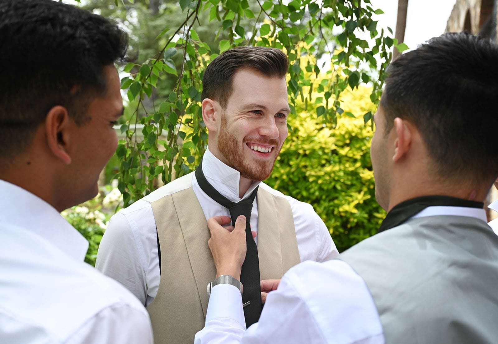 the manor basket range wedding - cassie & danny 5 Smiling groom as groomsmen adjusts tie