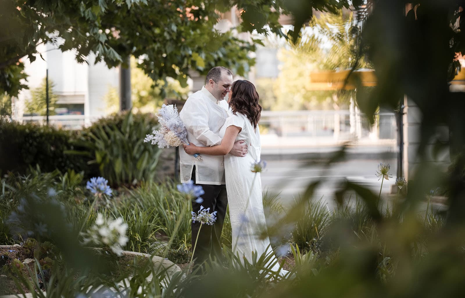 st francis xaviers cathedral wedding - sash & dan 47 Bride and groom betwen foliage at ayres house