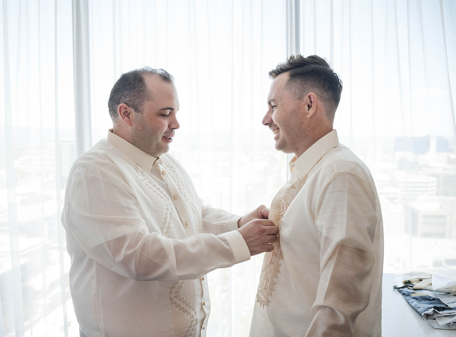st francis xaviers cathedral wedding - sash & dan 17 Groom buttoning shirt of groomsman