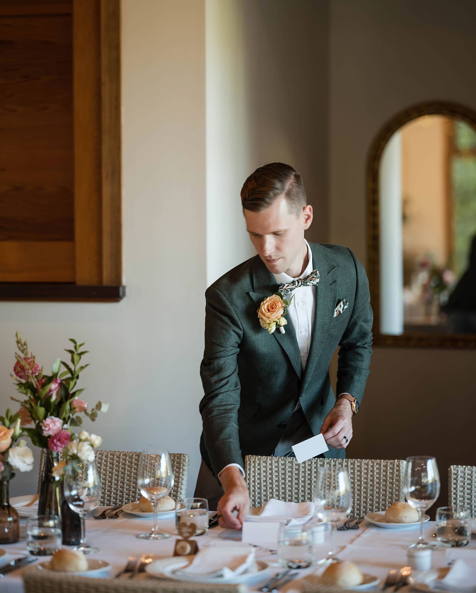 k1 winery wedding - mitch & nick 144 Groom putting finsihing touches on tables