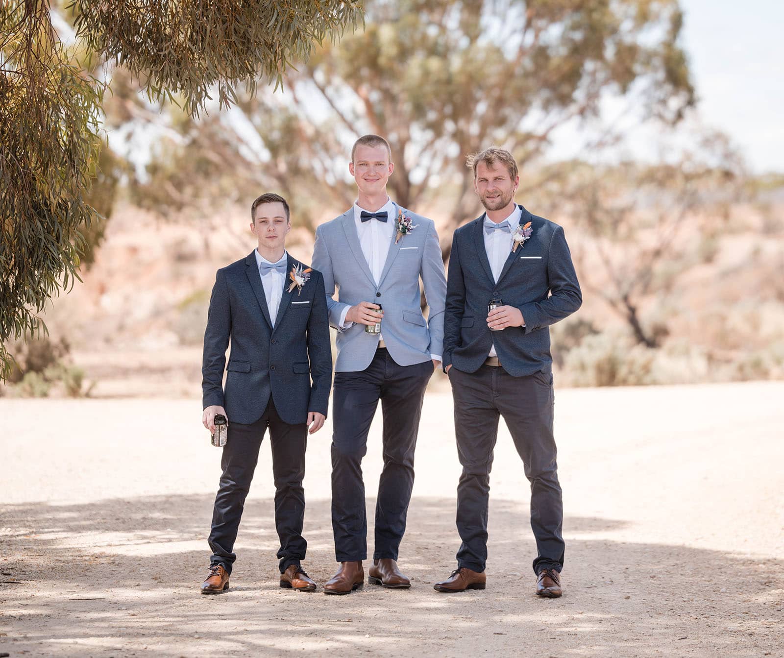 riverland wine centre wedding - lisa & mitch 171 Groom standing with groomsmen on dusty road
