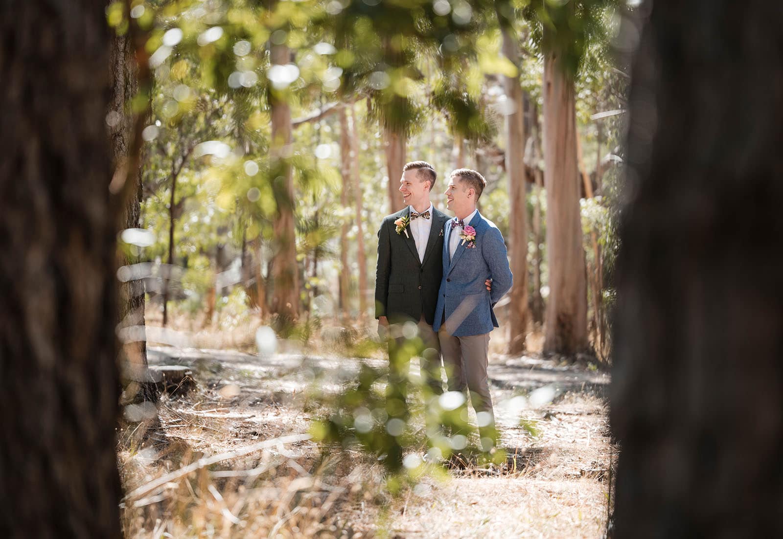 k1 winery wedding - mitch & nick 101 Grooms looking into difference through trees
