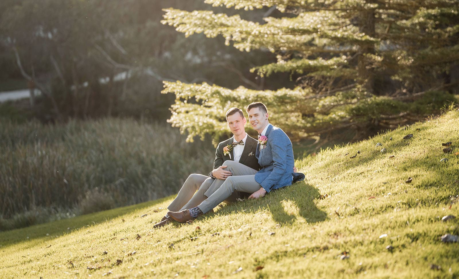 k1 winery wedding - mitch & nick 130 Grooms sitting toegtehr under sun