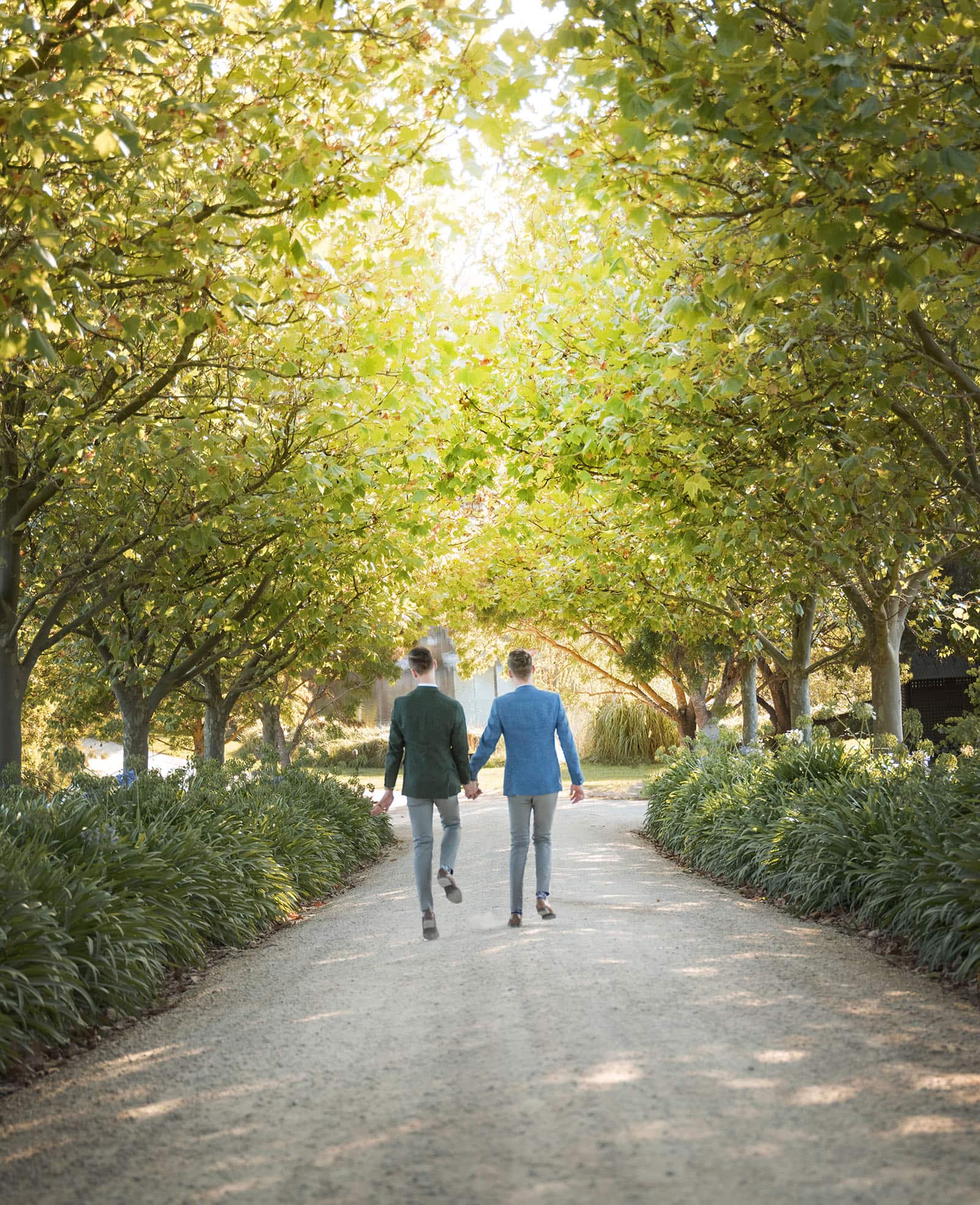 k1 winery wedding - mitch & nick 125 Grooms skipping under trees