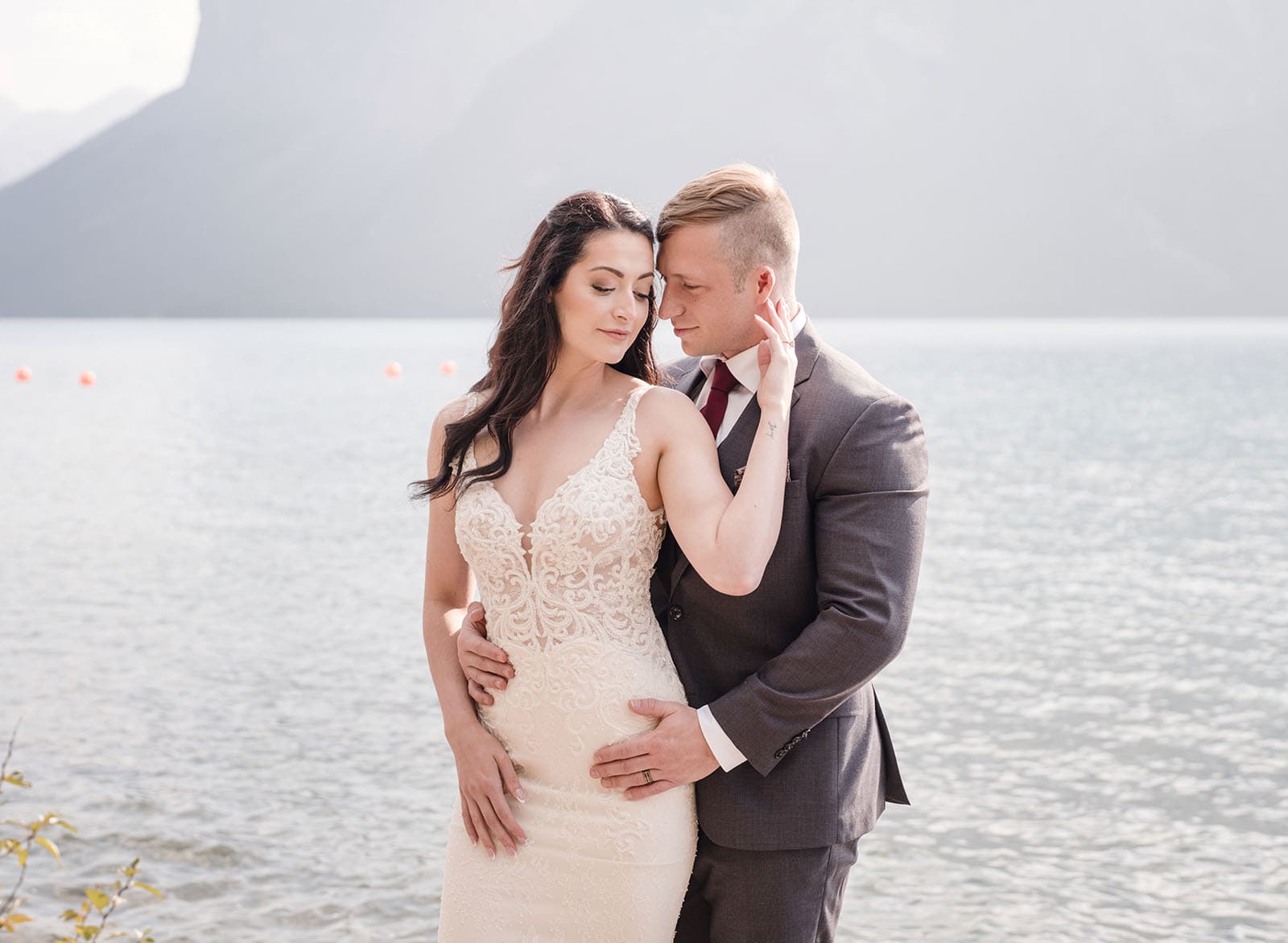 canada's lake louise wedding photoshoot - melodie & brandon 10 Bridal embrace on lake shore
