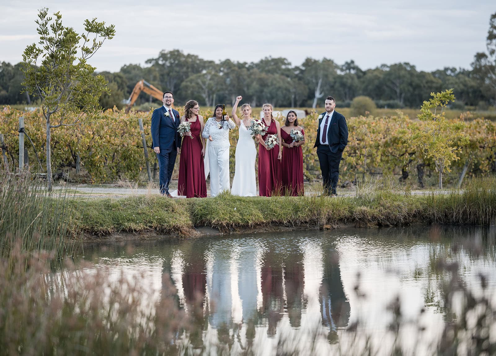 vine shed wedding - kat & katie 240 Bridal party spraying champaigne over pond