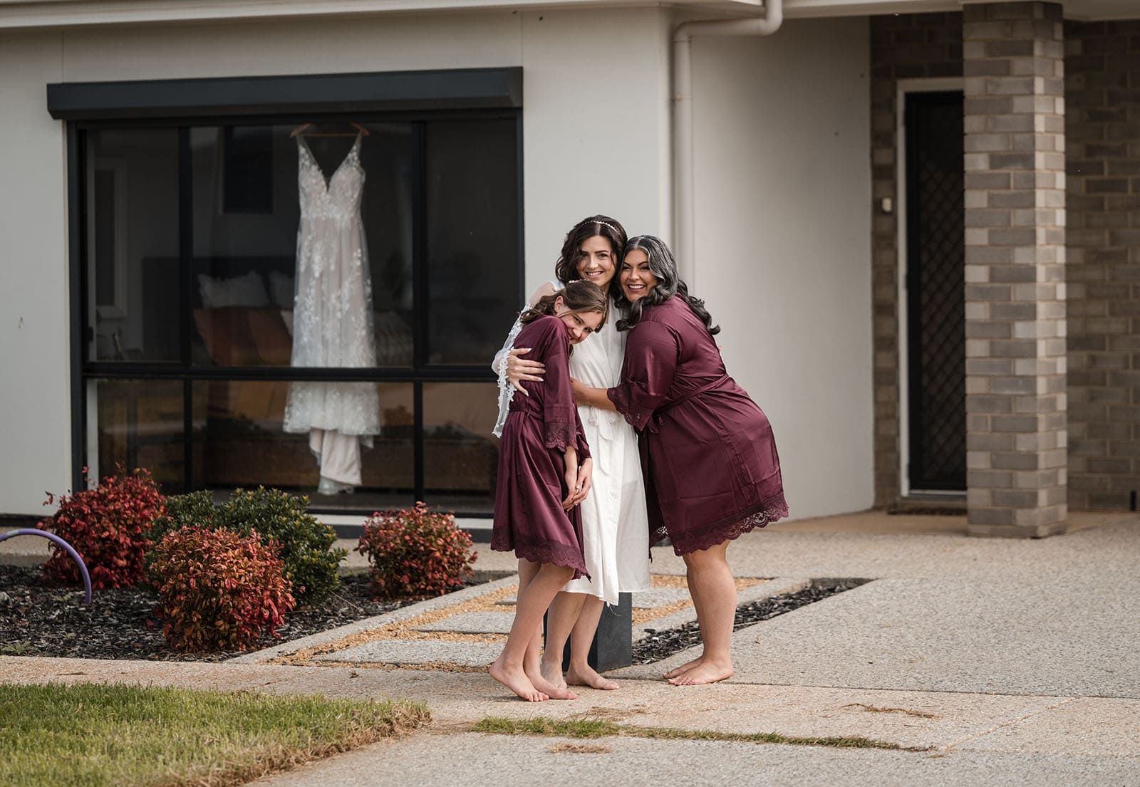 sneakys wedding - ash & michael 64 Bride and bridesmaids in gowns out front of house