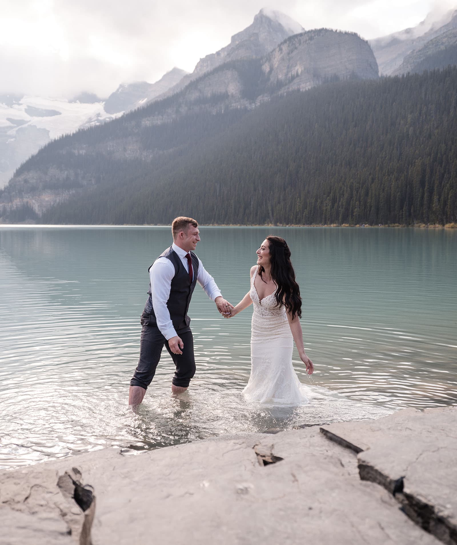 canada's lake louise wedding photoshoot - melodie & brandon 20 Bride and groom having fun in water of Lake Louise