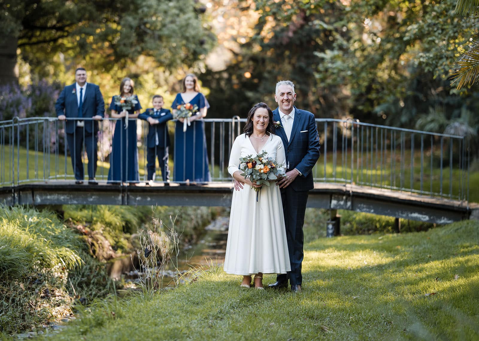 northern palm garden wedding - nicole & daryl 127 bride and groom in front of bridge with bridal party