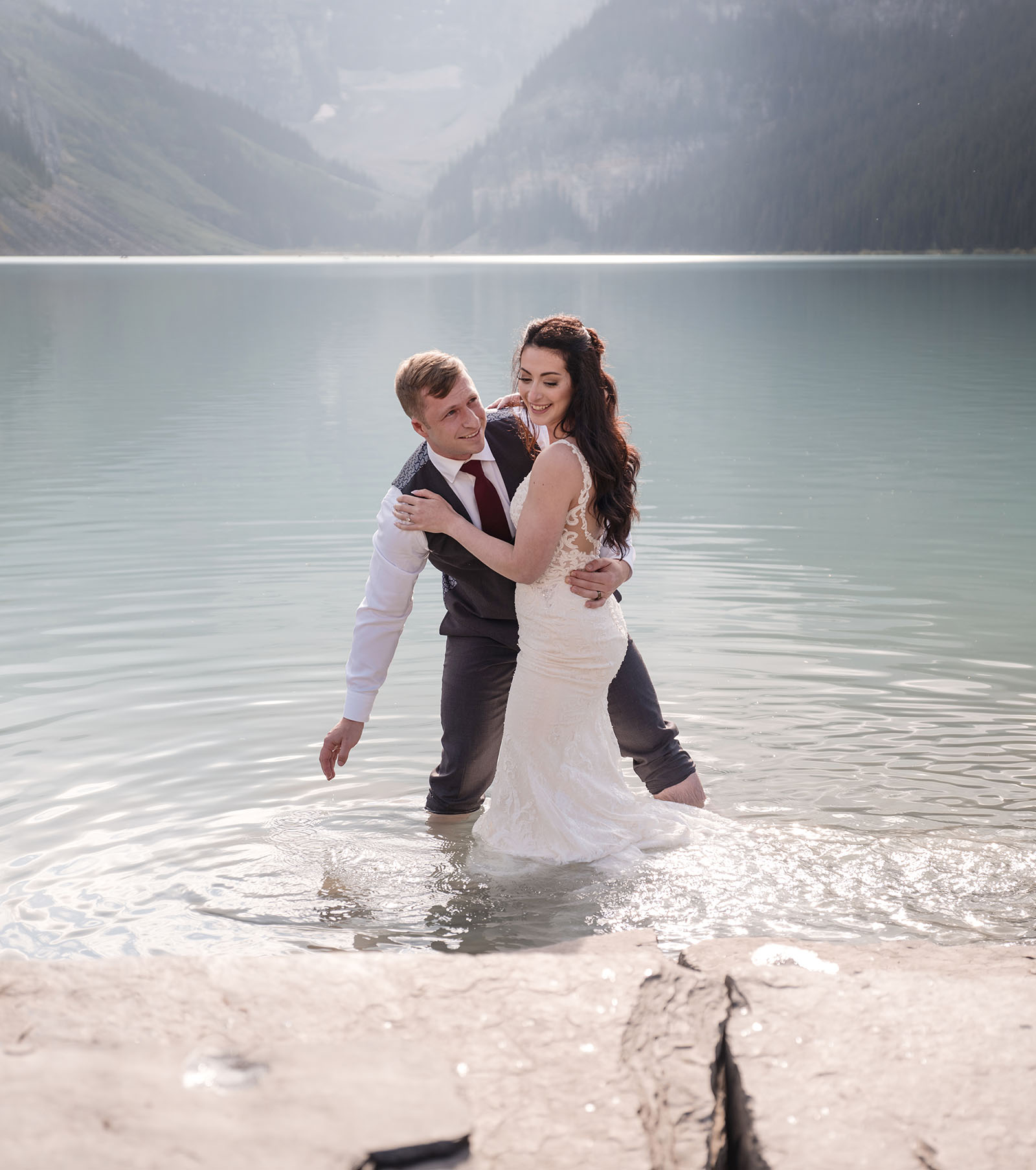 canada's lake louise wedding photoshoot - melodie & brandon 18 Bride and groom splashing one another