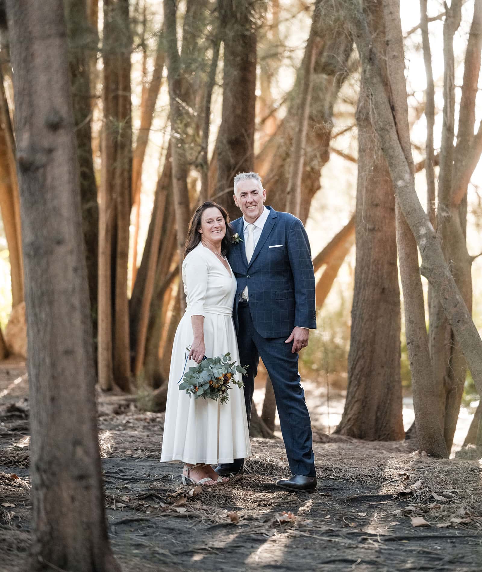 northern palm garden wedding - nicole & daryl 138 Bride and groom standing together in the trees
